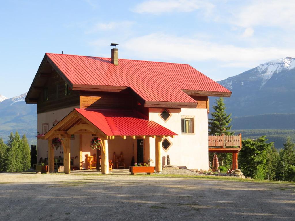 a building with a red roof with a mountain in the background at Tschurtschenthaler Lodge in Golden