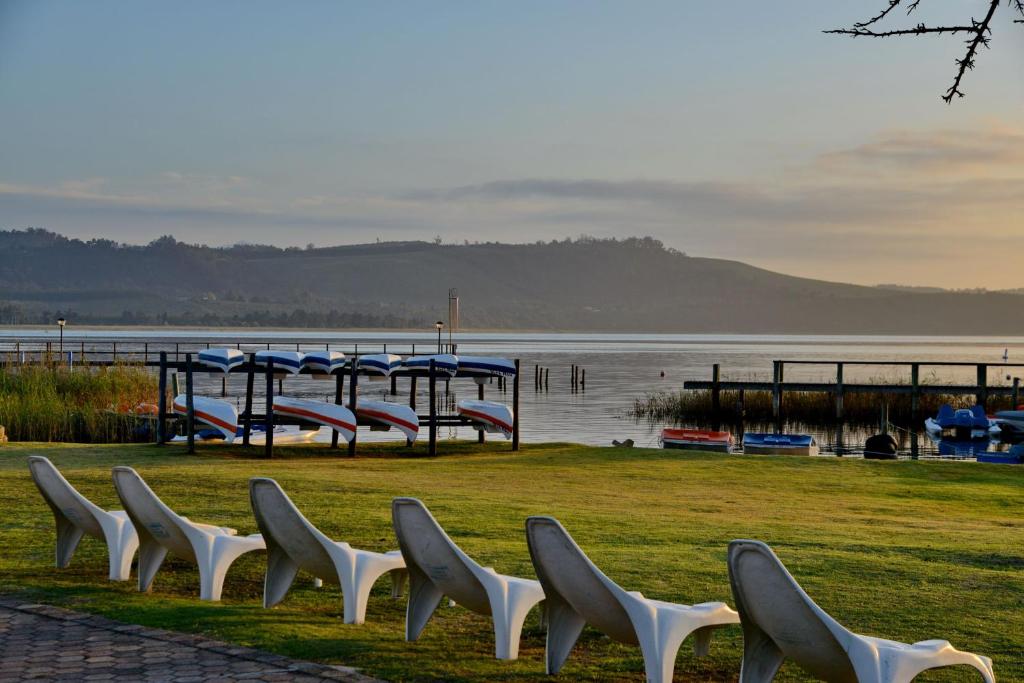 a row of white chairs sitting next to a body of water at Baywater Village by MyResorts in Sedgefield