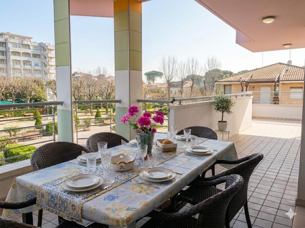 a table with plates and glasses and flowers on a patio at PIOPPETO EST - Premium Villas in Giulianova