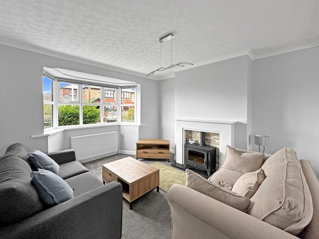a living room with two couches and a fireplace at Modern Contractor House - Lockable Gated Parking in Kiveton Park