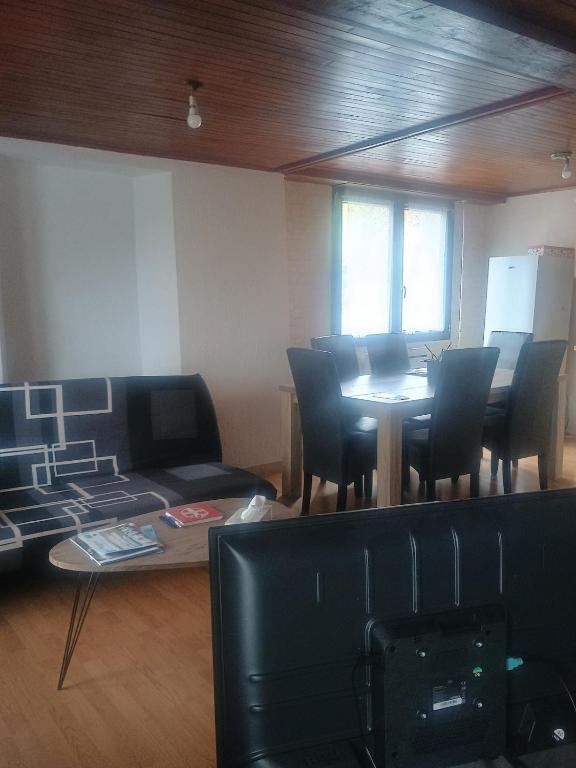 a living room with a table and chairs and a couch at Maison neuvecelle in Neuvecelle
