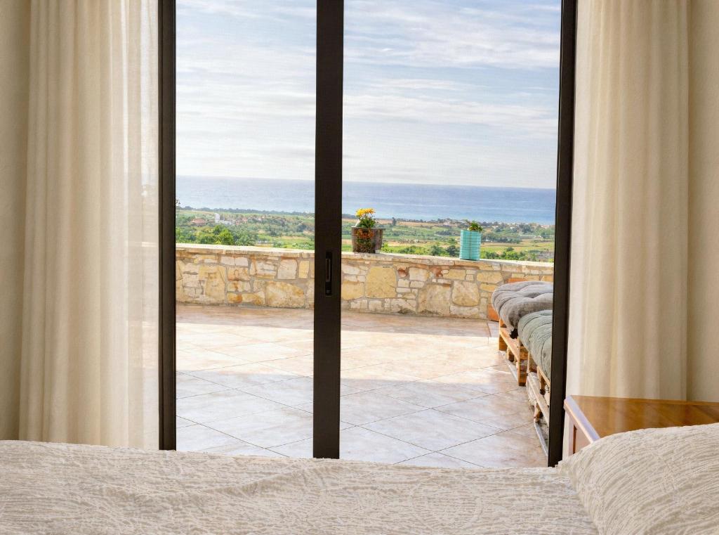 a bedroom with a sliding glass door to a patio at Filia Garden in Samos