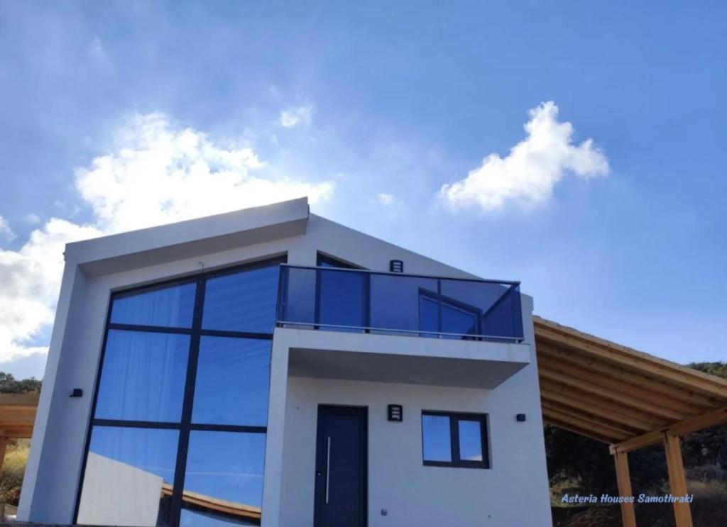 a house with a lot of glass windows at Asteria Houses Samothraki in Samothraki