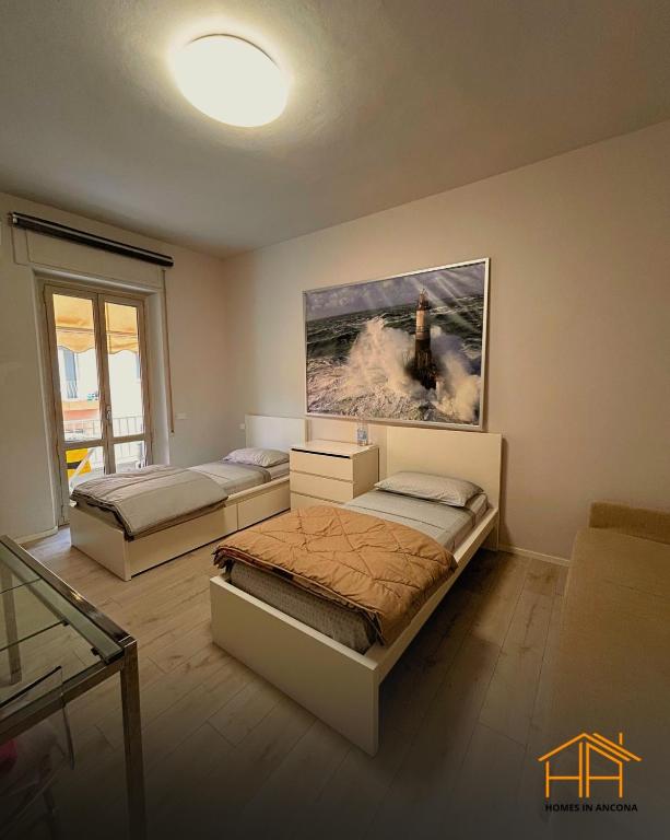 a room with two beds and a painting on the wall at VVR6 Rooms by Homes in Ancona in Ancona