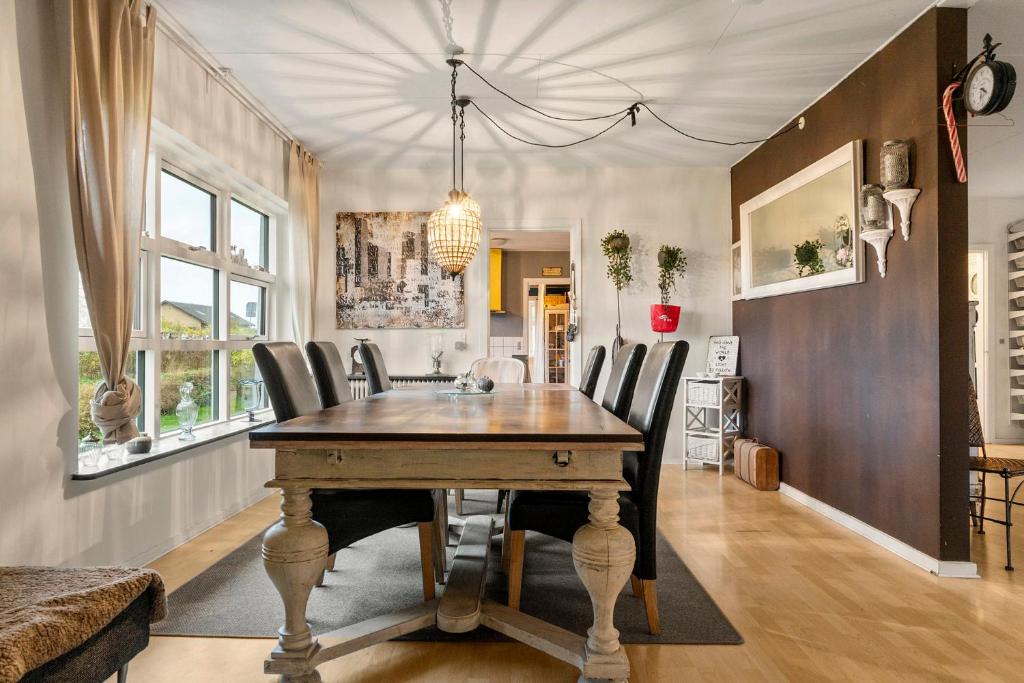 a dining room with a wooden table and chairs at Den Gamle Apotekergaard in Høng