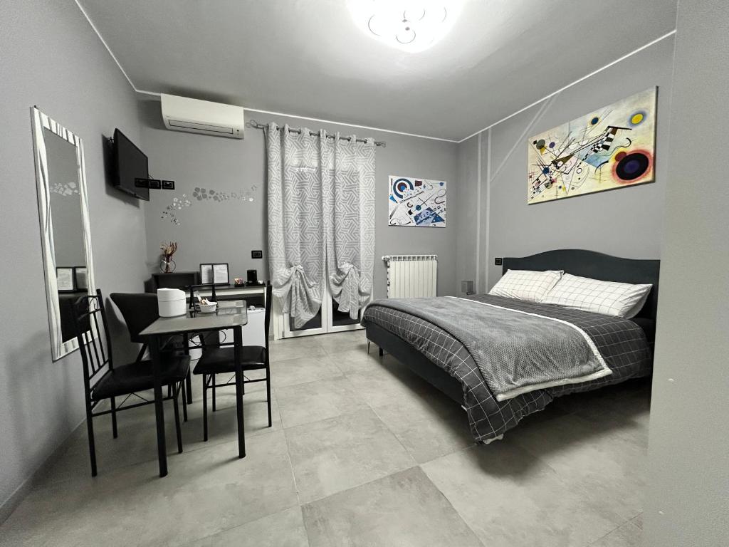 a bedroom with a bed and a table and a desk at B&B Art in Silvi Marina