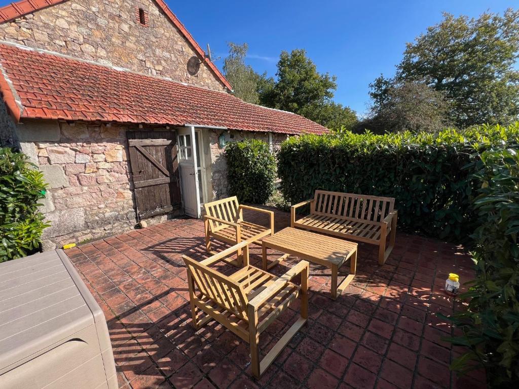 two wooden benches sitting on a brick patio at Tiny Gite La Petite Grue in Louroux-Bourbonnais