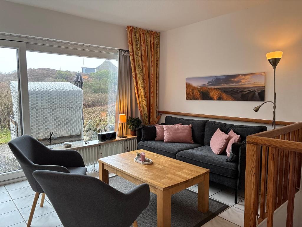 a living room with a couch and a table at Vierfuss 1A in Hörnum