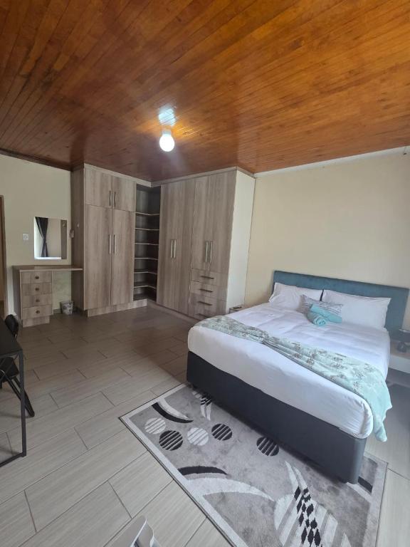 a bedroom with a large bed and a wooden ceiling at The Second Tranquilo in Ermelo