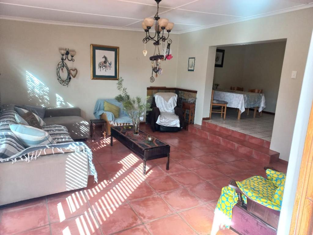 a living room with a couch and a table at Bird cottage in Barrydale