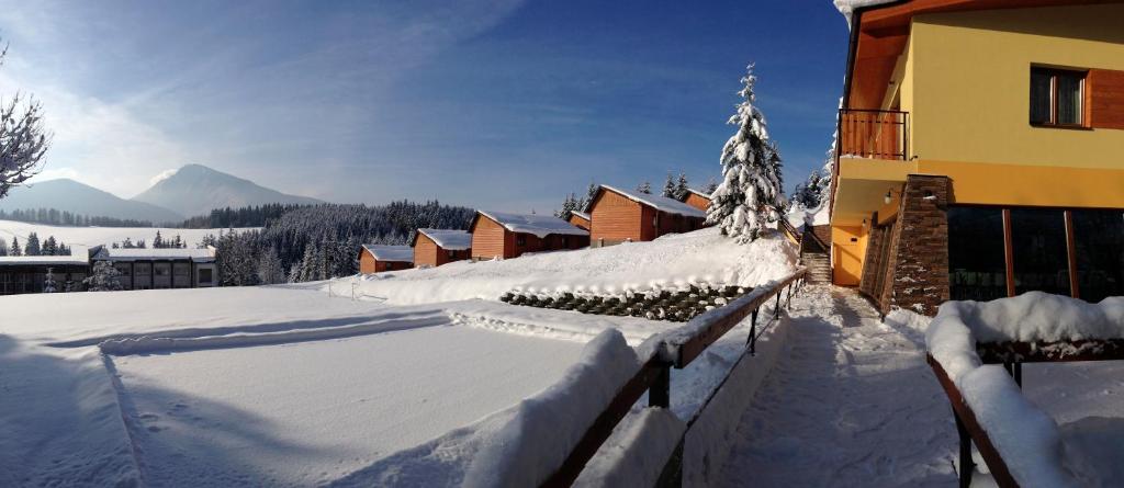 a snow covered yard in front of a building at Holiday Park Orava - Hotel Orava in Dolný Kubín