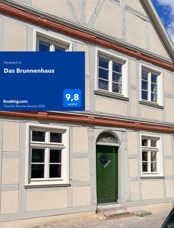 a sign on the side of a building with a green door at Das Brunnenhaus in Tangermünde