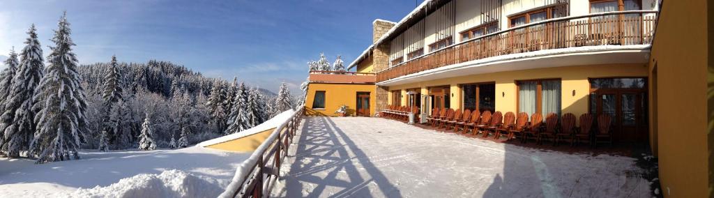 a building in the snow with a snowboarding ramp at Holiday Park Orava - Hotel Orava in Dolný Kubín