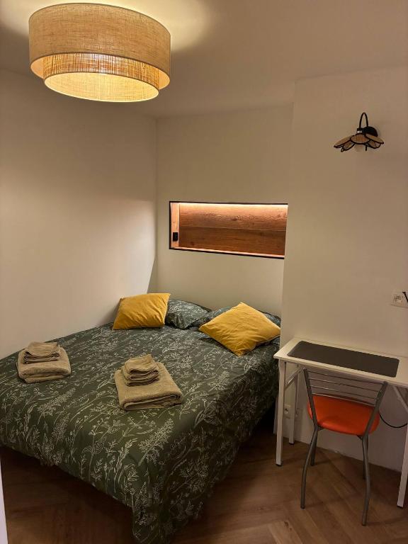 a bedroom with a bed with yellow pillows and a table at Location de Chambre SDB Cuisines in Charleroi