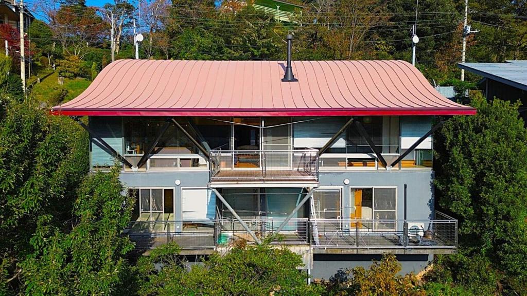 a large white house with a red roof at 熱海ブレスアネックス in Atami