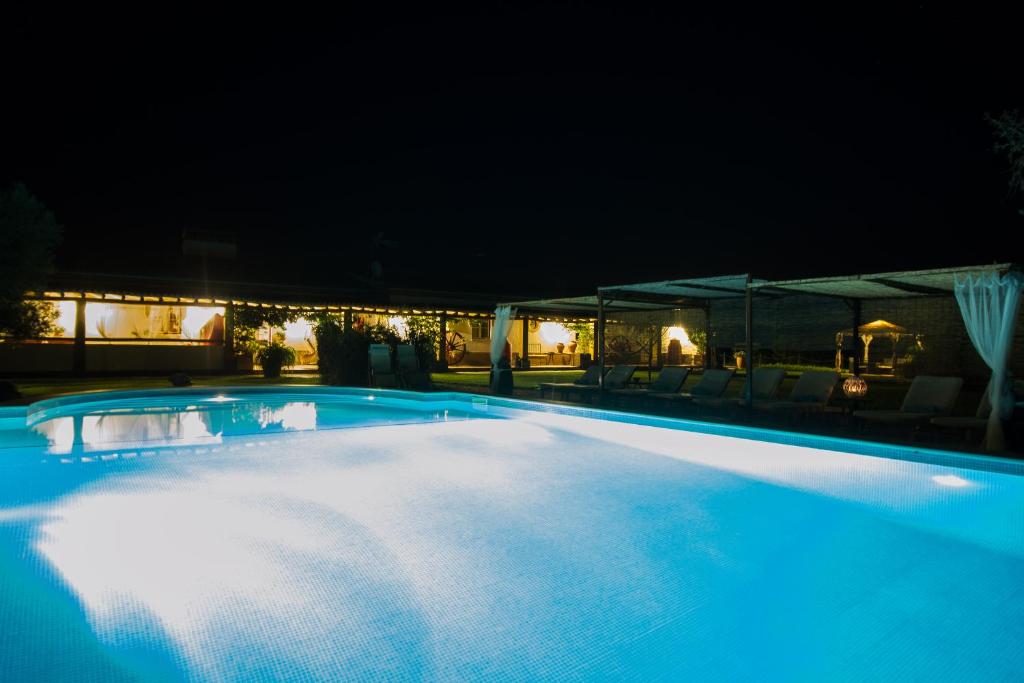 uma grande piscina iluminada à noite em Monte Chalaça - Turismo Rural em Ferreira do Alentejo