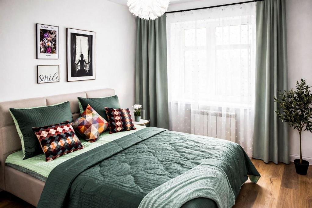 a bedroom with a bed with a green blanket and a window at kleine Fine in Lübeck
