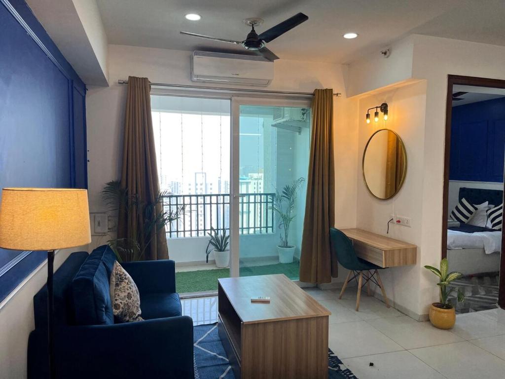 a living room with a blue couch and a table at Azure by Grehstay in Noida