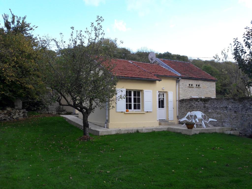 a house with a statue of a cow in a yard at Gite Le Verger in Commes