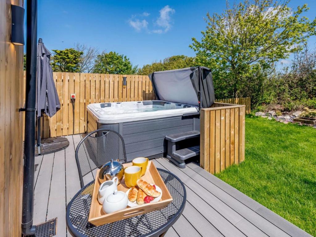 a deck with a hot tub and a tray of food at 1 Bed in Woolacombe oc-82341 in Woolacombe