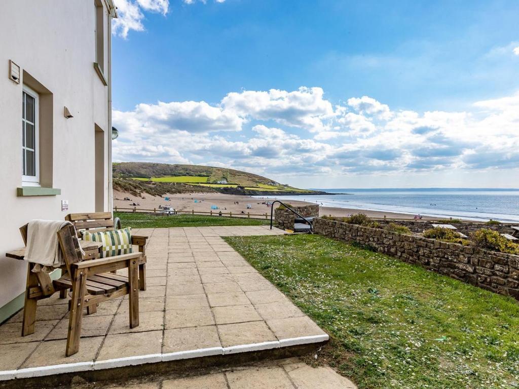 a patio with a bench and a view of the beach at 3 Bed in Braunton oc-87107 in Croyde