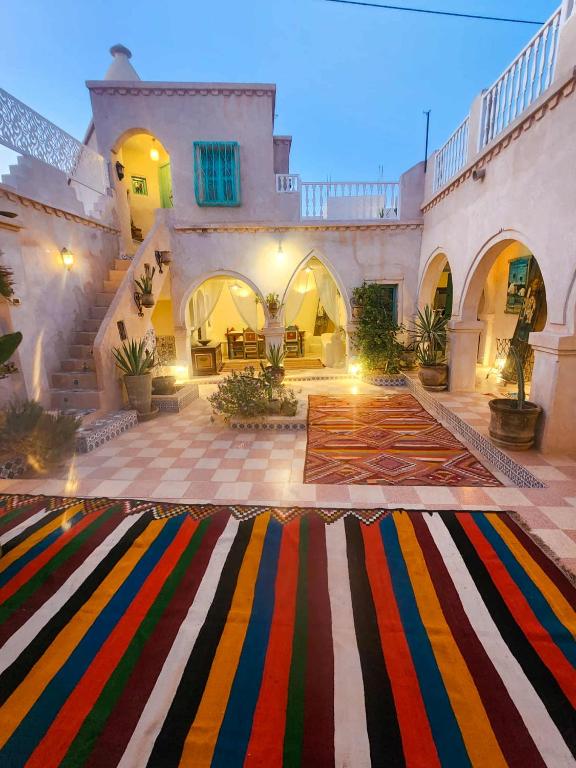 a courtyard with a colorful rug in front of a building at Chambre d'hôtes medenine in Medenine