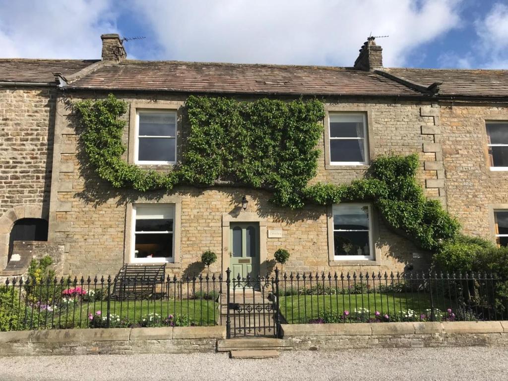 an ivy covered house with a fence at 3 Bed in Leyburn oc-g0185 in Carlton