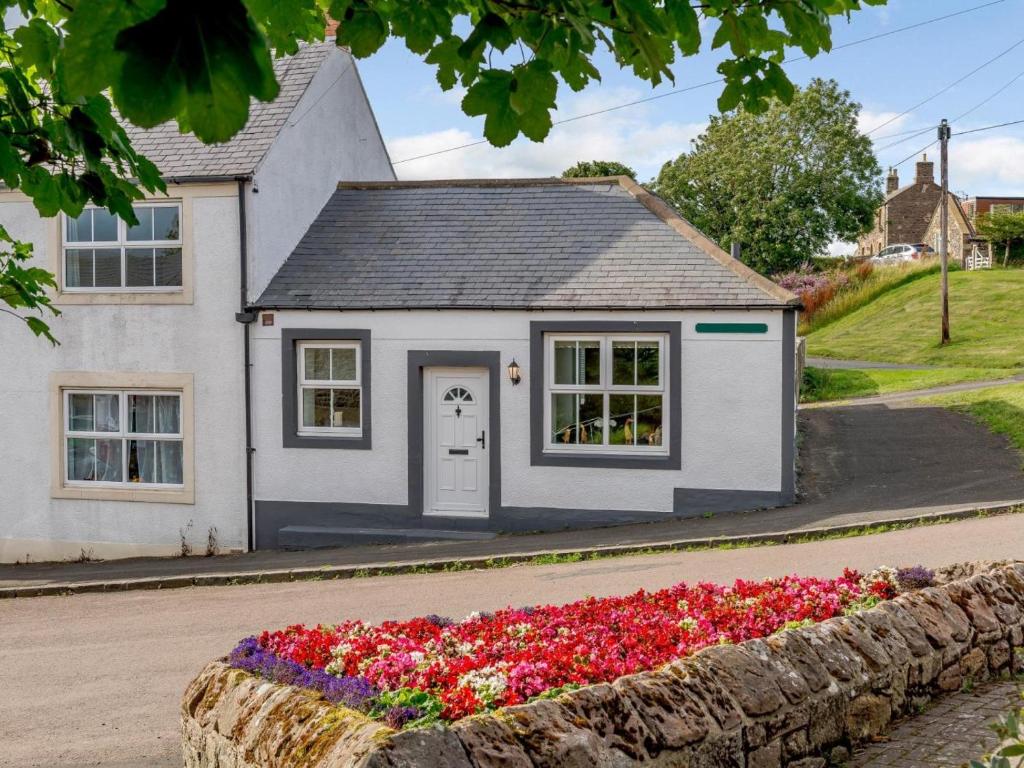 a house with a flower bed in front of it at 2 Bed in Alnwick oc-78956 in Embleton