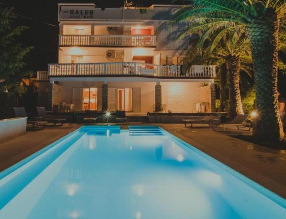 a large swimming pool in front of a building at Seagull Pool Apartments & Studios in Novalja