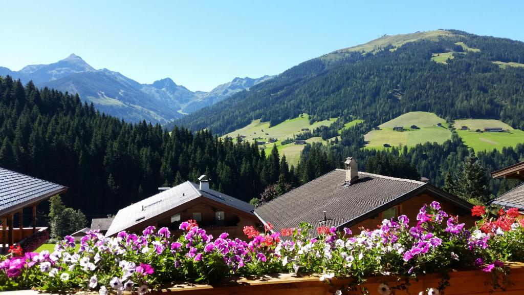 a bunch of flowers on a balcony with mountains at Hanslerfeld in Alpbach