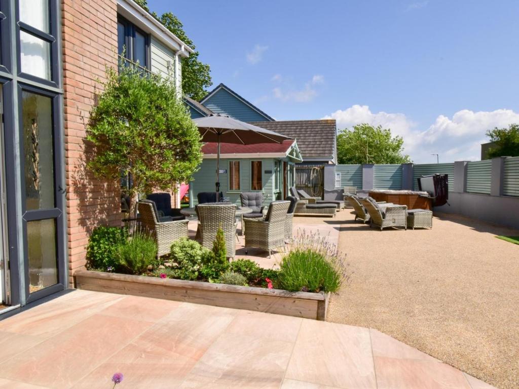 a patio with chairs and an umbrella at 5 Bed in Braunton oc-78250 in Braunton