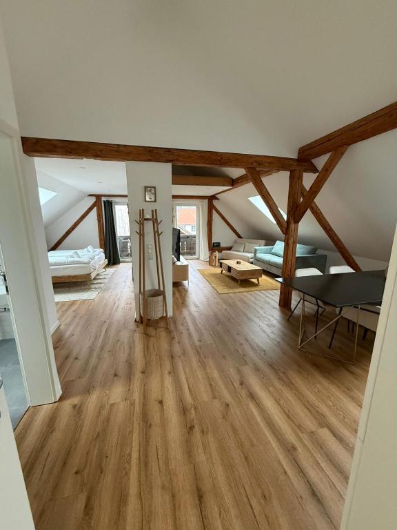 a living room with wooden floors and a loft at ღLIBORIA I Loft am Riegsee in Aidling