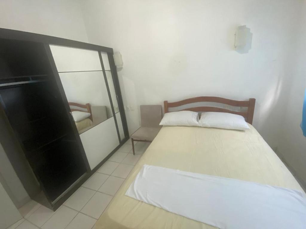 a small bedroom with a bed and a mirror at Hostel Suites in Recife