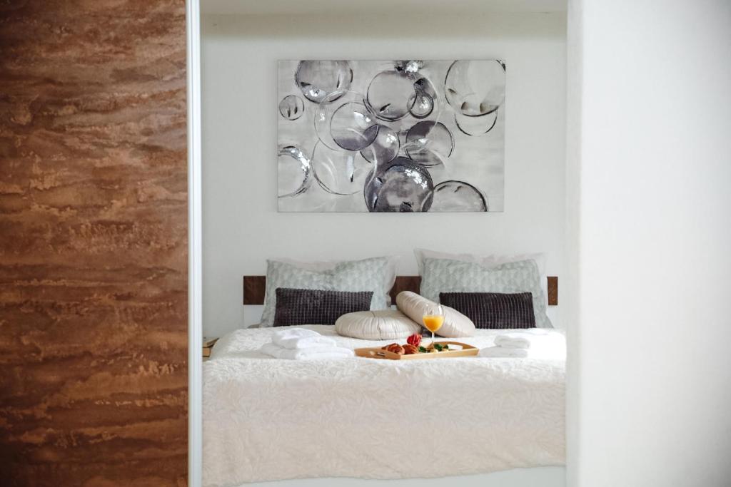 a white bed with a plate of food on it at Apartman Incerum in Požega