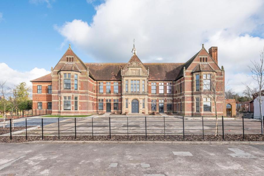 a large brick building with a fence in front of it at No 4 The Halesworth in Halesworth