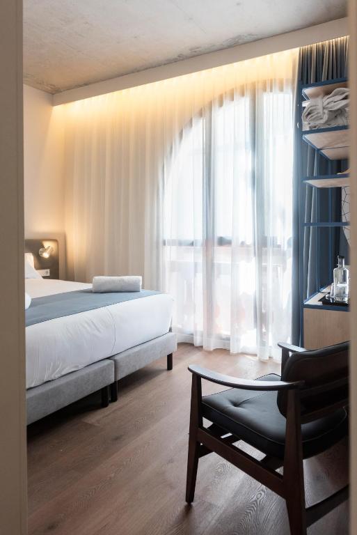 a bedroom with a bed and a large window at Hotel La Casa Del Sol in Barcelona