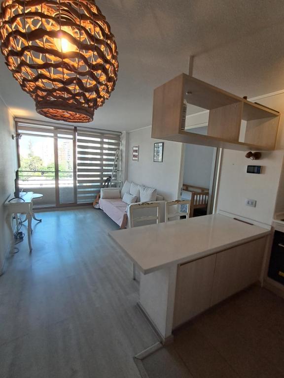 a kitchen and living room with a large chandelier at Plaza ñuñoa in Santiago