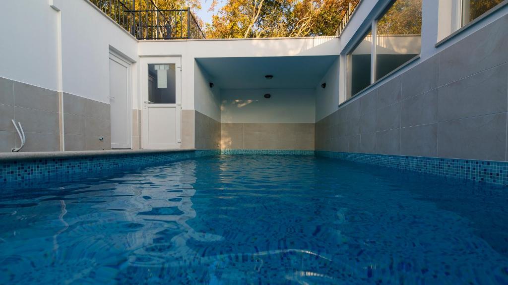 an indoor swimming pool with blue water in a house at Lavanda 3 in Njivice