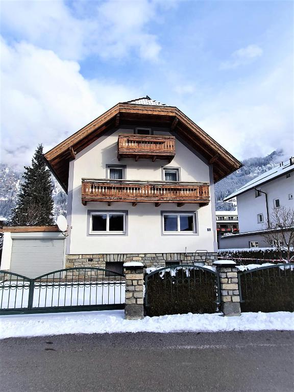 a white house with a wooden roof at Alpenchalet Mitterlechner in Bad Hofgastein