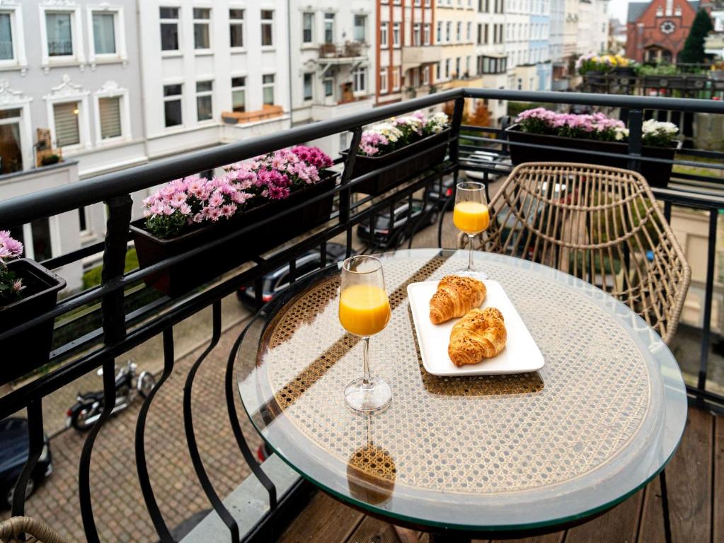 a table on a balcony with two glasses of orange juice at Altstadt Geverdes 3 in Lübeck