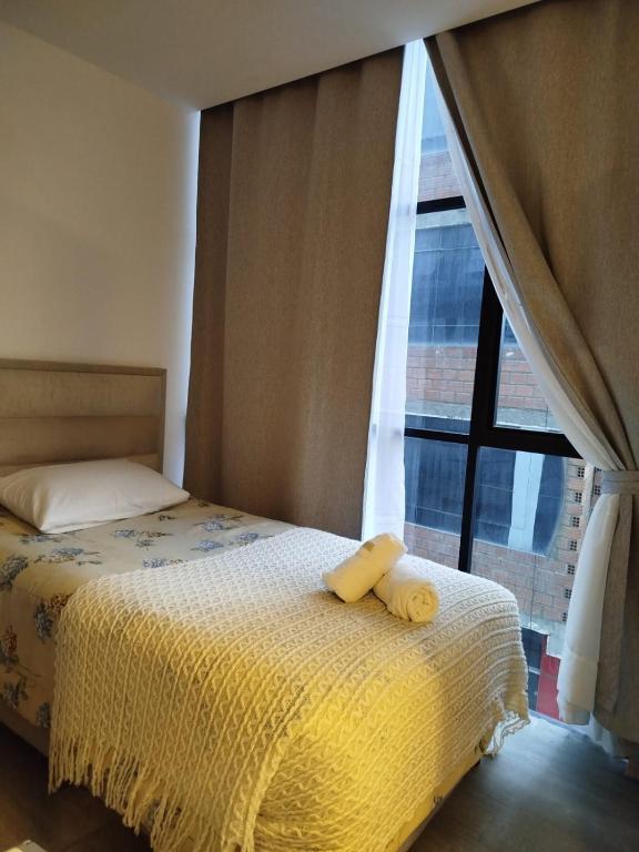 a bedroom with a bed with two yellow towels on it at Loft Individual Exclusivo in Estación El Alto