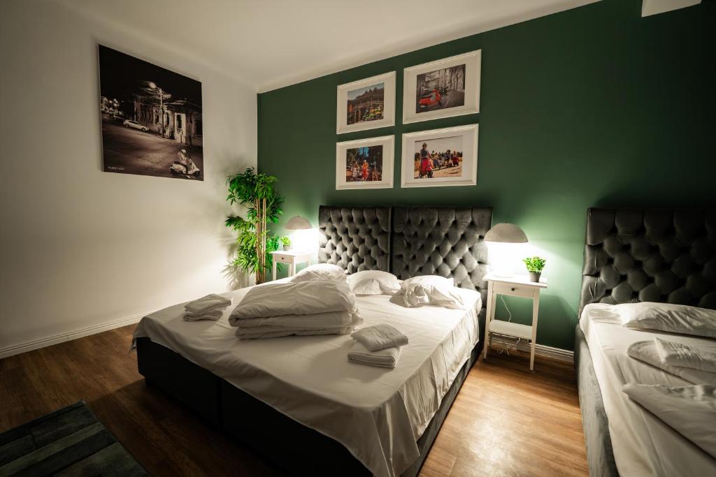 a bedroom with a bed and a green wall at Pit Stop Baby in Ploieşti
