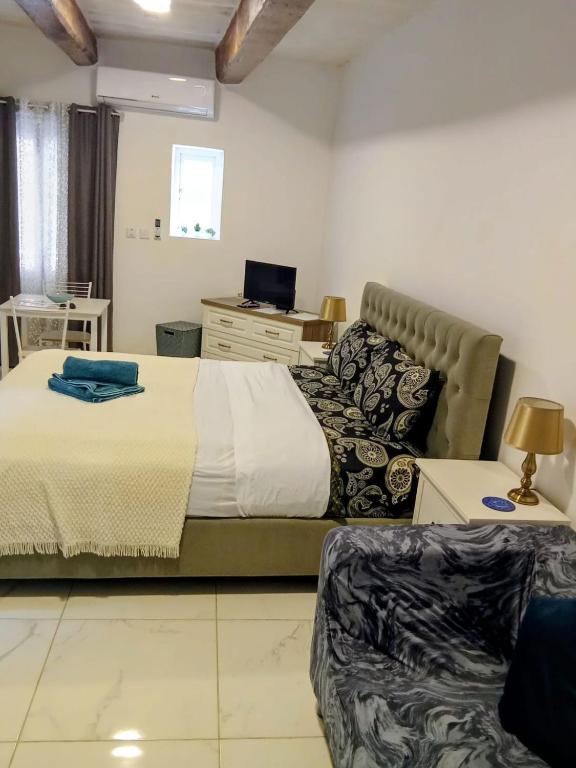 un dormitorio con una cama y un sofá en Valletta Malta, en Floriana