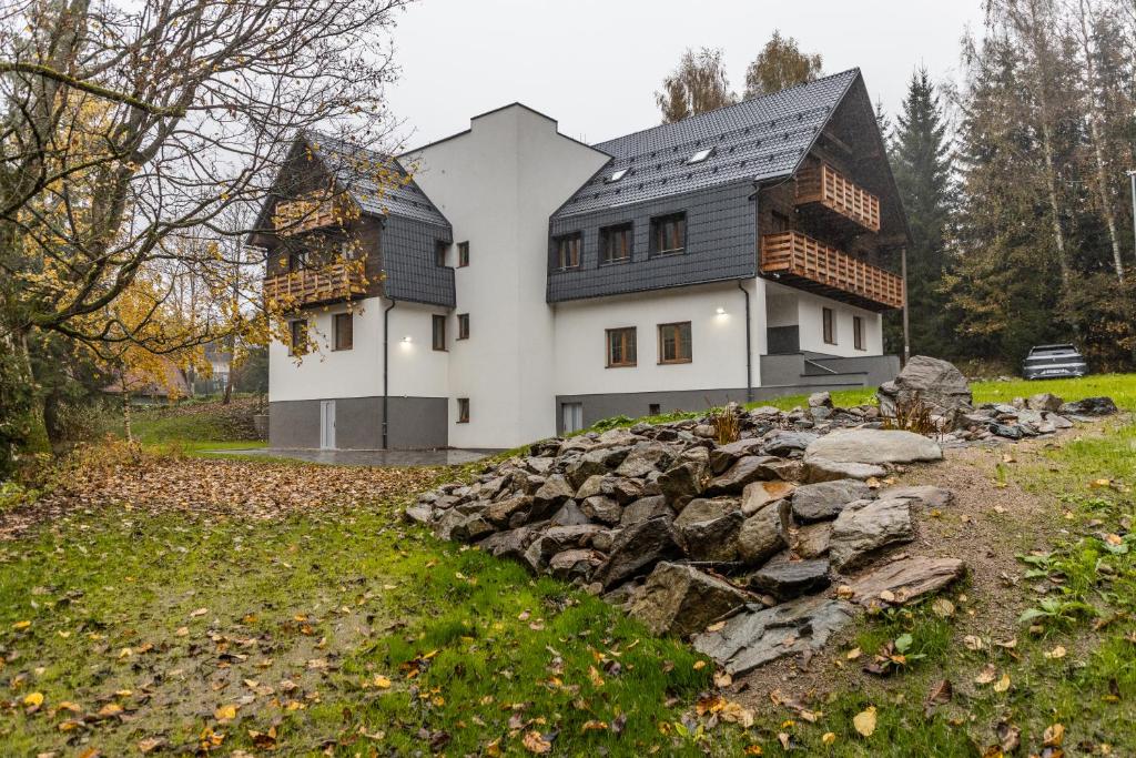a house with a pile of rocks in front of it at Apartmány Deštné 251 in Deštné v Orlických horách