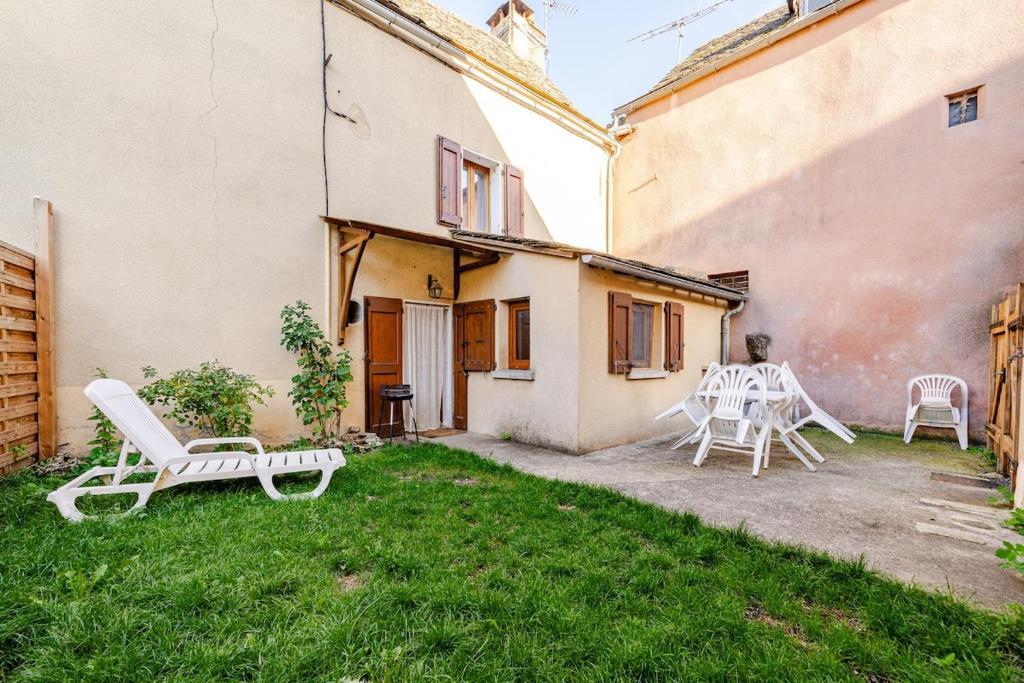 a yard with two chairs and a table and chairs at Maison avec jardin in Chirac