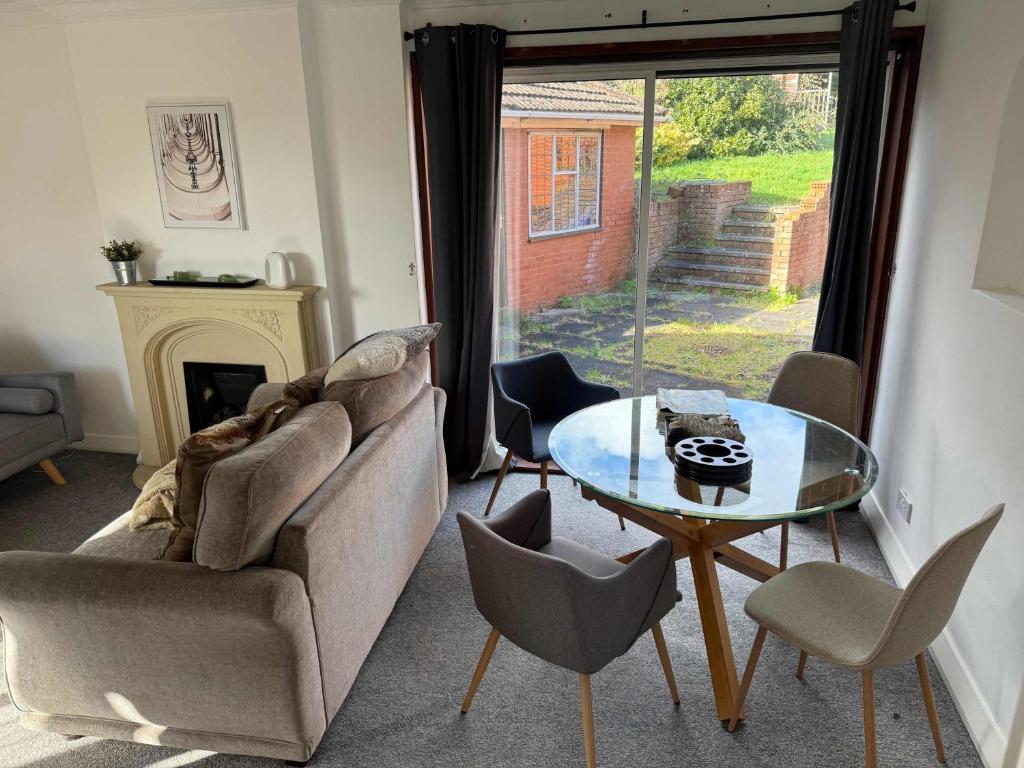 a living room with a couch and a glass table at Large 4 Bed with Parking in Hillmorton