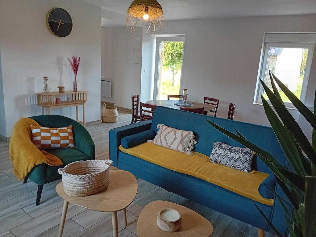 a living room with a blue couch and a table at Le gîte d'Elisa in Roullours