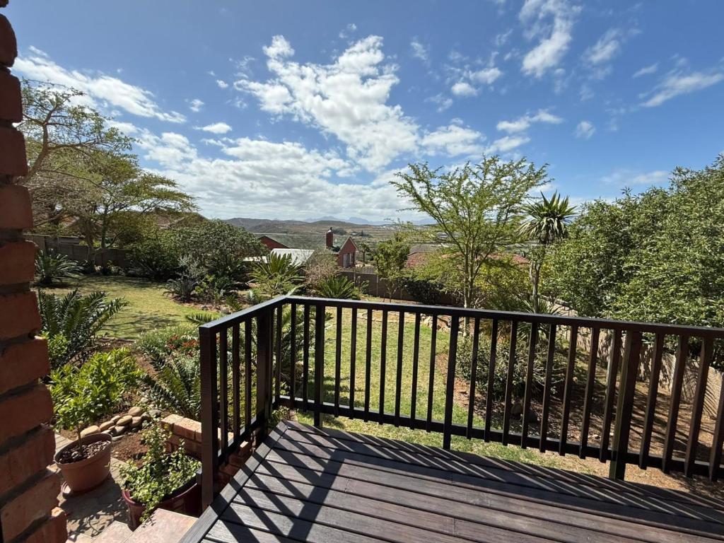 a balcony with a fence and a view of a yard at Hettie's Cottage in Hartenbos