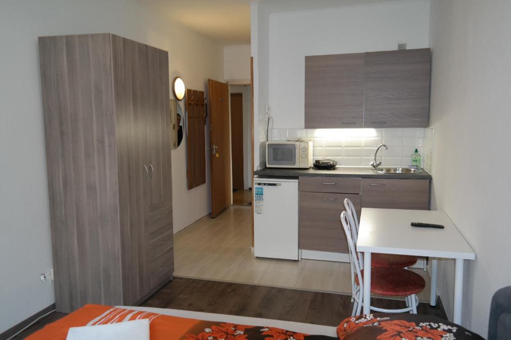 a small kitchen with a table and a microwave at West City Apartments in Budapest