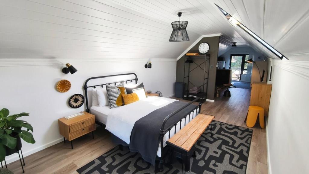a bedroom with a bed and a clock on the wall at Lorraine Loft Apartment in Gqeberha